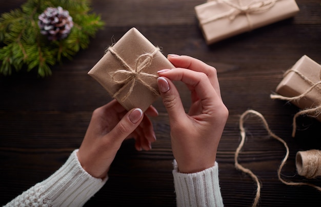 Mains boîtes de cadeaux bruns avec chaîne de maintien