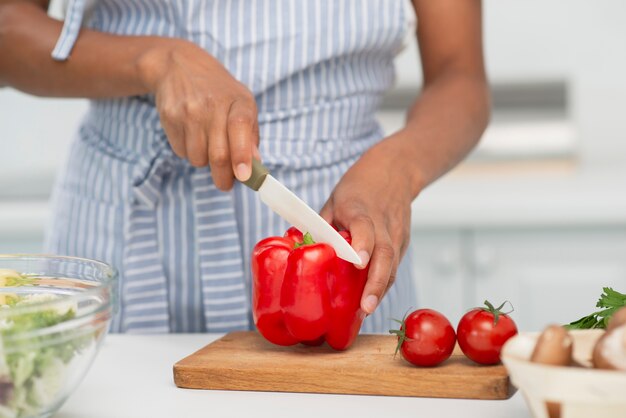 Mains coupant un délicieux poivron rouge