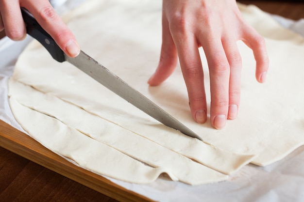 Photo gratuite mains coupant la pâte achetée en magasin