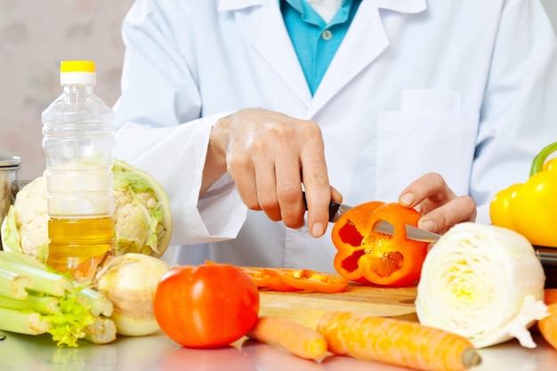 les mains coupent les légumes