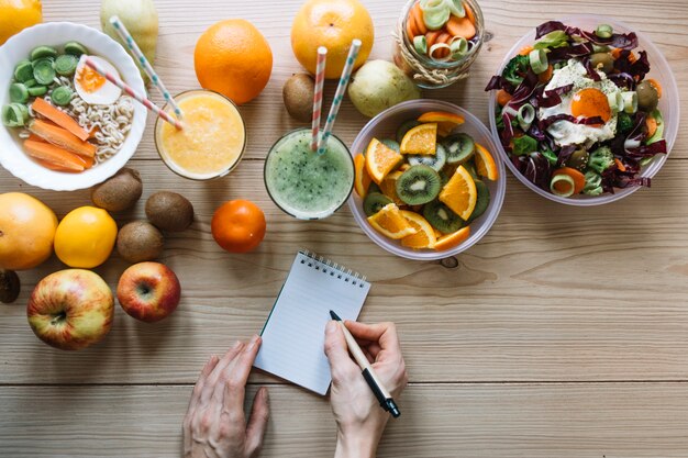 Mains de la culture d&#39;écriture près de la nourriture saine