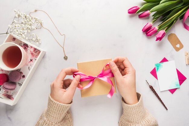 Mains décorant le cadeau de fête des mères