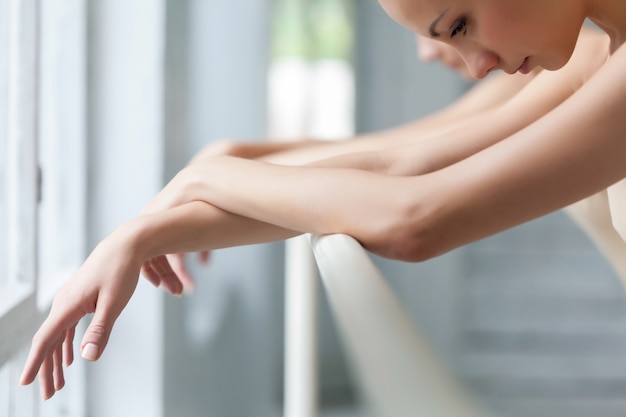 Les mains de deux danseurs de ballet classique à barre