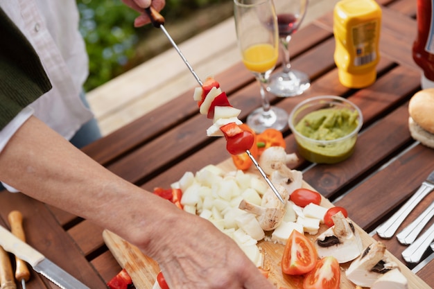 Mains faisant des brochettes à angle élevé