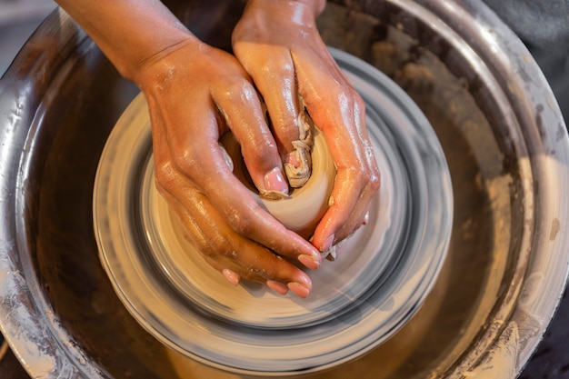 Mains faisant de la poterie se bouchent