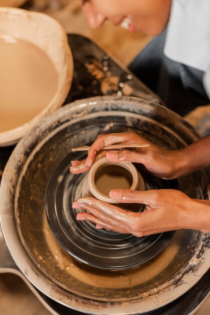 Mains faisant de la poterie se bouchent