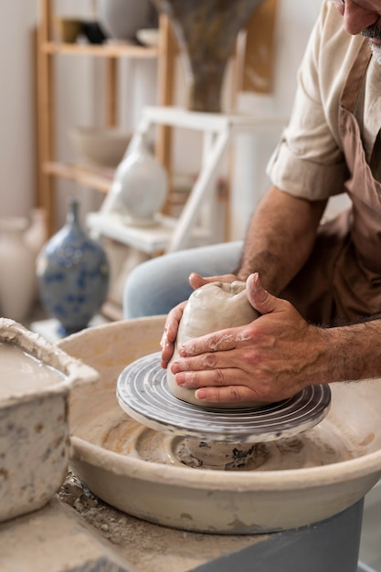 Mains faisant de la poterie se bouchent