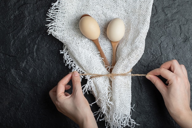 Photo gratuite les mains femelles attachent la toile de jute avec des oeufs