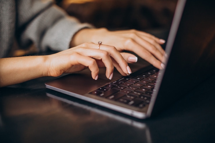 Photo gratuit mains féminines tapant sur le clavier de l'ordinateur