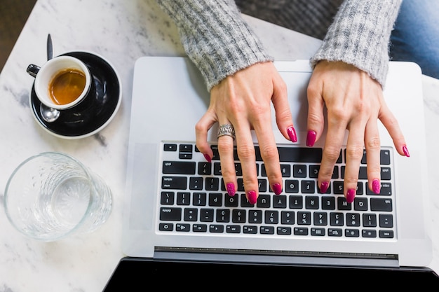 Mains féminines, tapant sur ordinateur portable