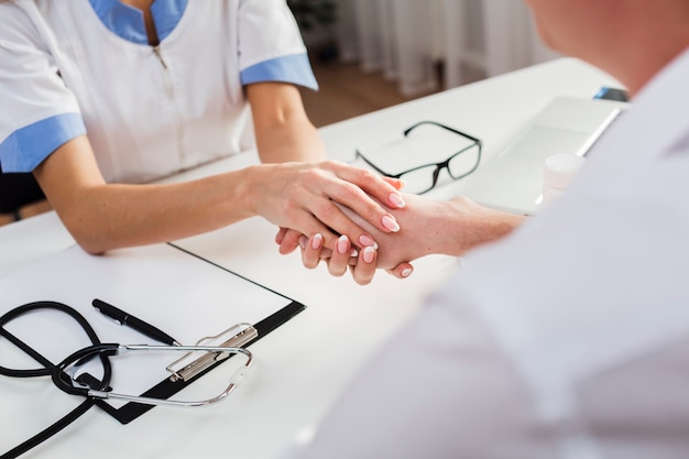 Mains féminines tenant la main du patient