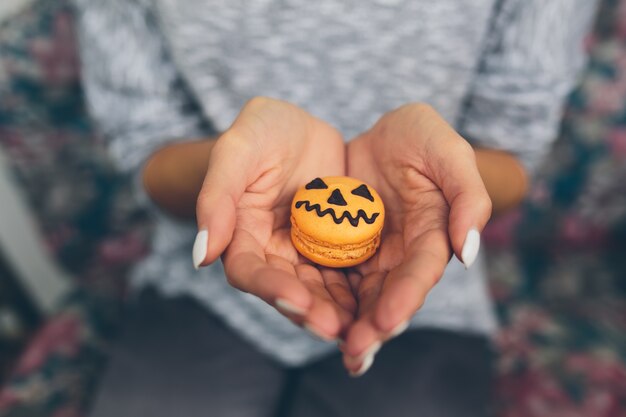 les mains de femme avec un cookie de citrouille