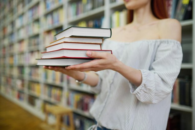 Mains de femme tenant une pile de livres