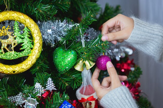 les mains de la femme touchent l'ornement de Noël