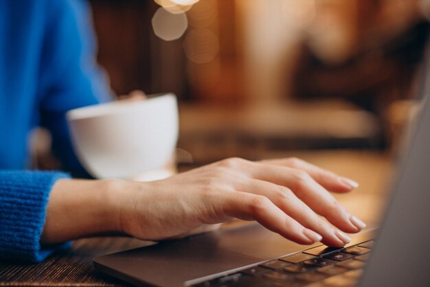 Les mains des femmes se bouchent en tapant sur le clavier d'un ordinateur portable