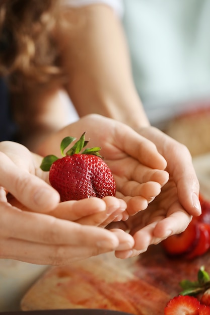 Mains avec des fraises fraîches