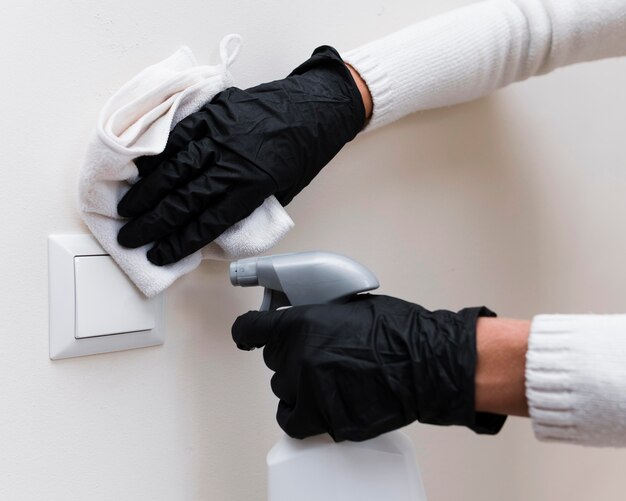 Mains avec des gants interrupteur de lumière de désinfection