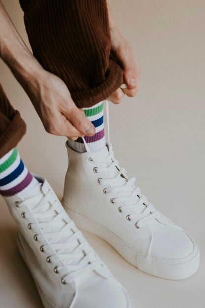 Mains d'homme attachant des lacets sneaker blanc