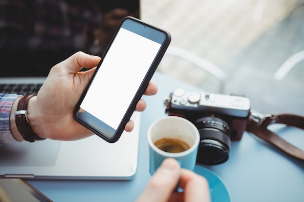 Mains de l'homme exécutif tenant tout en prenant un café