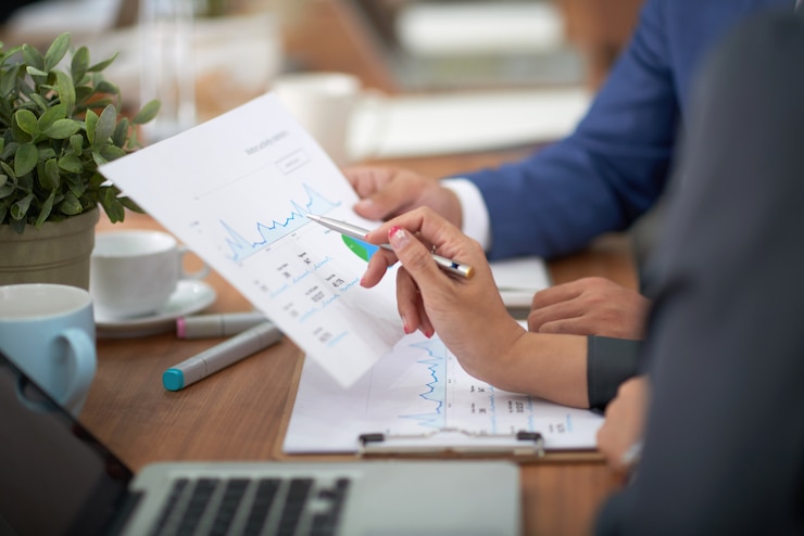 Photo gratuit mains d'homme et femme en tenue professionnelle assis au bureau dans le bureau et en discutant graphique