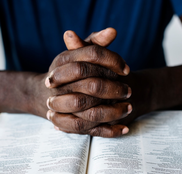 Mains d&#39;hommes afro-américains reposant sur une bible ouverte