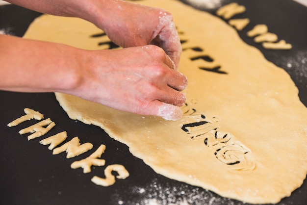 Mains humaines enlevant des lettres de pâte