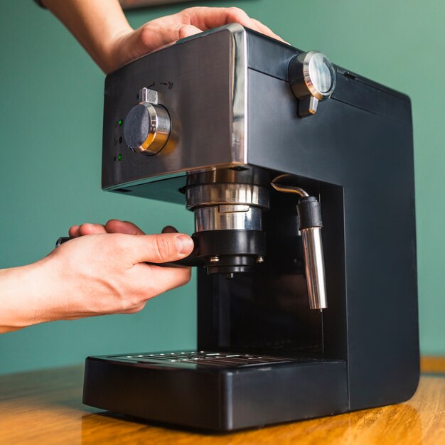 Les mains installent le filtre dans la cafetière