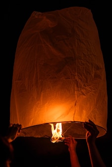 Les mains libèrent des lanternes célestes (montgolfière) lanterne céleste flottante dans le nord de la thaïlande, nouvel an traditionnel, festival yi peng et festival loy krathong