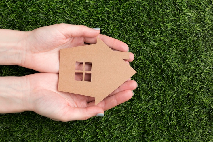Photo gratuit mains avec maison miniature