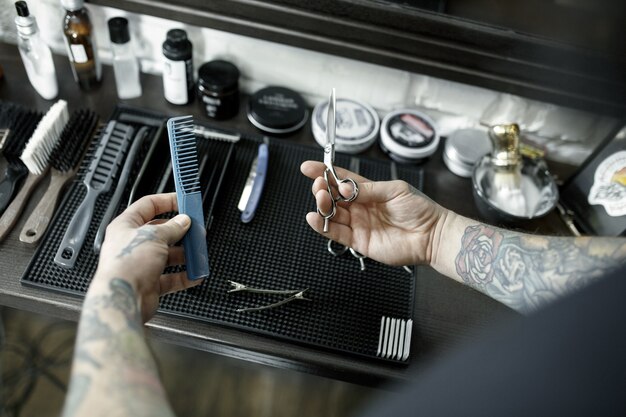 mains mâles et outils pour couper la barbe au salon de coiffure. Outils vintage de salon de coiffure.