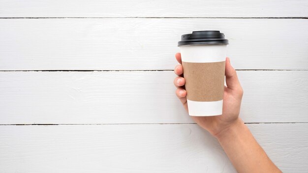 Mains mâles tenant une tasse à café recyclable. Idée de recyclage