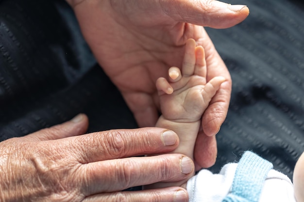 Photo gratuite mains d'une personne âgée et d'un petit bébé en gros plan