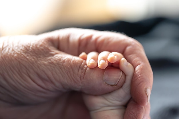 Photo gratuite mains d'une personne âgée et d'un petit bébé en gros plan