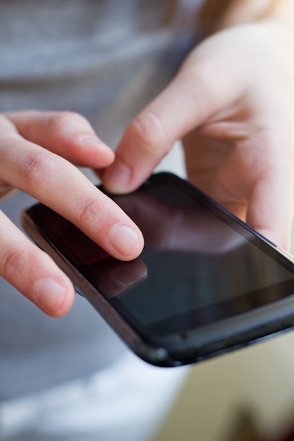 Les mains de la personne utilisant un téléphone