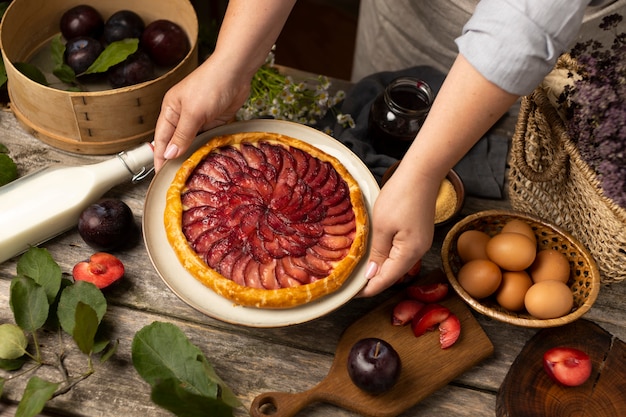 Photo gratuite mains tenant une assiette avec un angle élevé de tarte