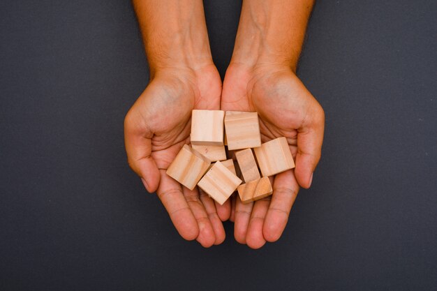 mains tenant des cubes en bois.