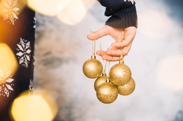 Mains tenant diverses boules de Noël