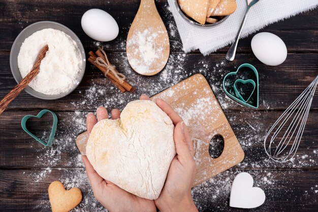 Mains tenant la pâte en forme de coeur