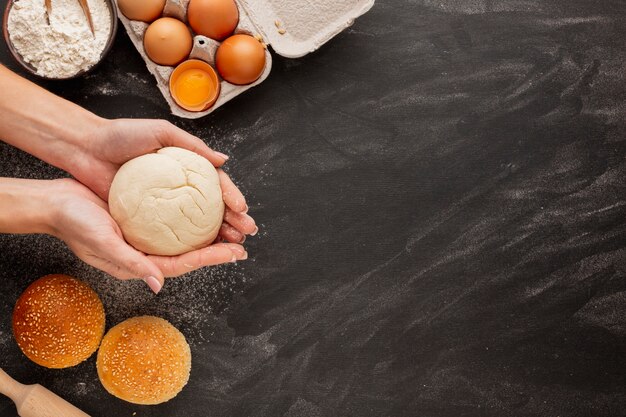 Mains tenant la pâte avec des oeufs et de la farine