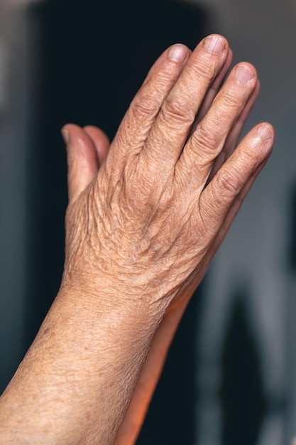 Mains d'une vieille femme pliées pour la prière