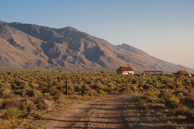 Maison blanche unique avec un toit brun en Californie, à côté des montagnes de la Sierra Nevada
