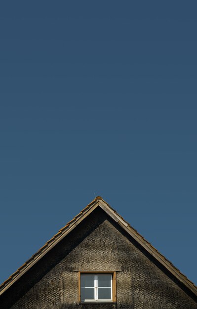 Maison brune et grise sous un ciel bleu pendant la journée