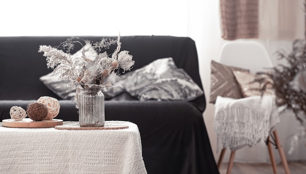 Photo gratuite maison de nature morte chaleureuse avec un canapé noir et une décoration dans le salon.