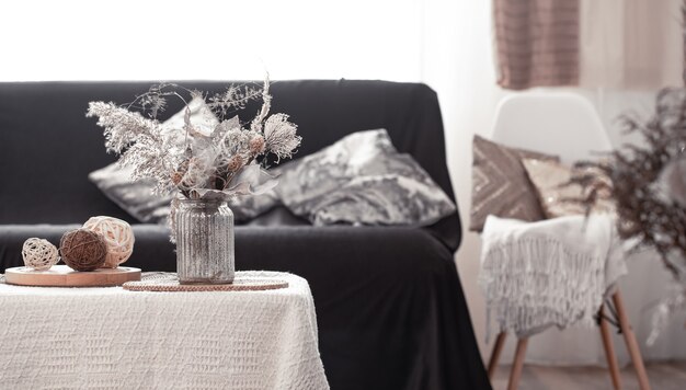 Maison de nature morte chaleureuse avec un canapé noir et une décoration dans le salon.