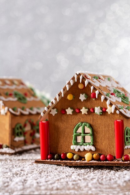 Maison de pain d'épice de Noël sur fond de paillettes blanches