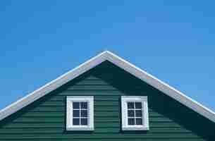 Photo gratuite maison verte et toit blanc avec ciel bleu en journée ensoleillée