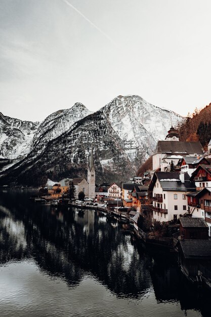 Maisons en béton brun et blanc près du plan d'eau et de la montagne