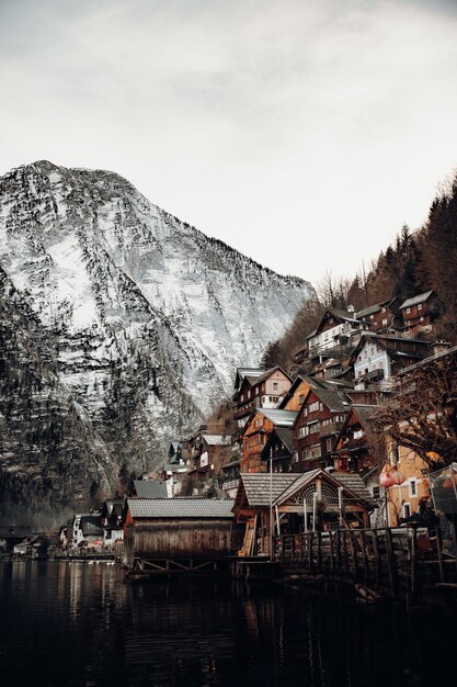 Maisons en béton brun et blanc près de la montagne sous un ciel blanc pendant la journée