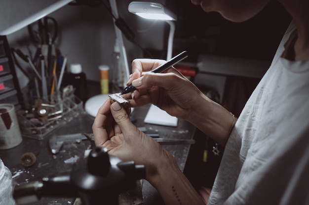 Le maître traite le métal précieux dans l'atelier de la maison