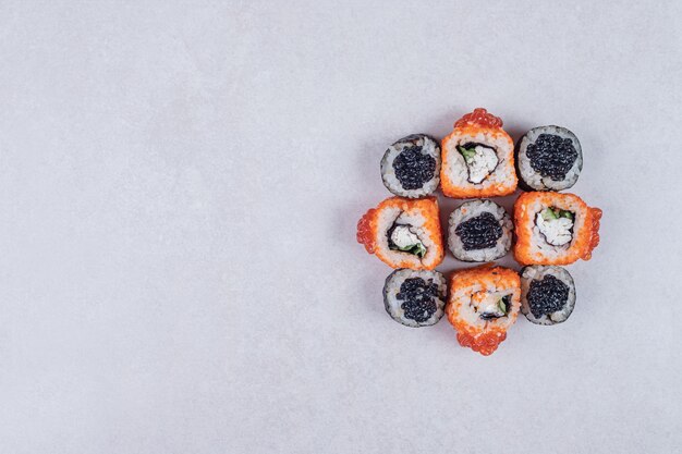 Maki et rouleaux de sushi de Californie sur fond blanc.